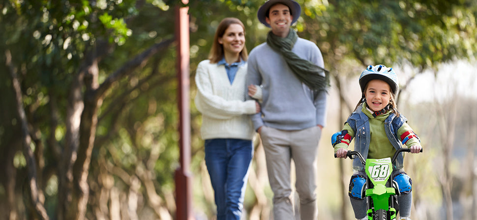 Family with a child on a bike in a park setting with text 'Happy Driving Harmonious Family'.