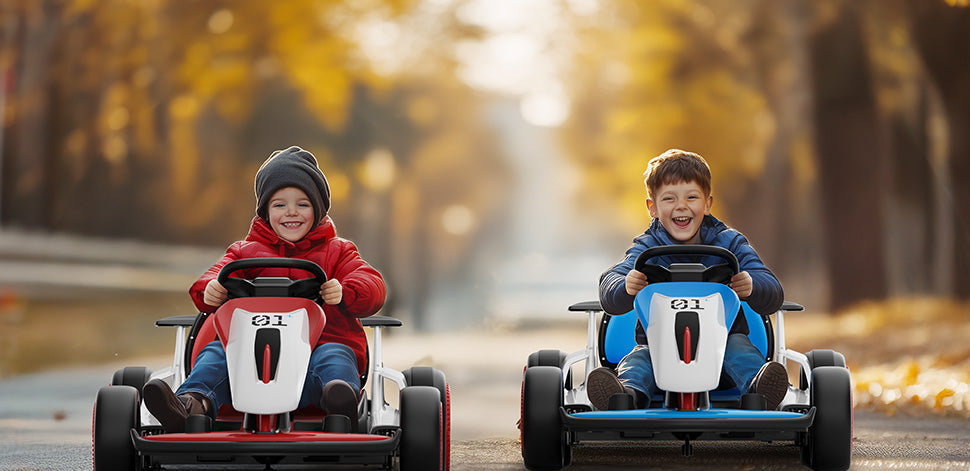 Two children in racing go karts on a road with trees in the background